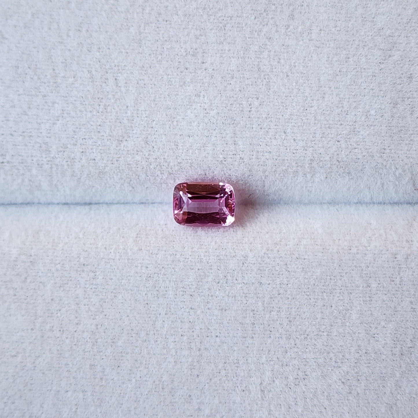 Pink gemstone on a light gray background