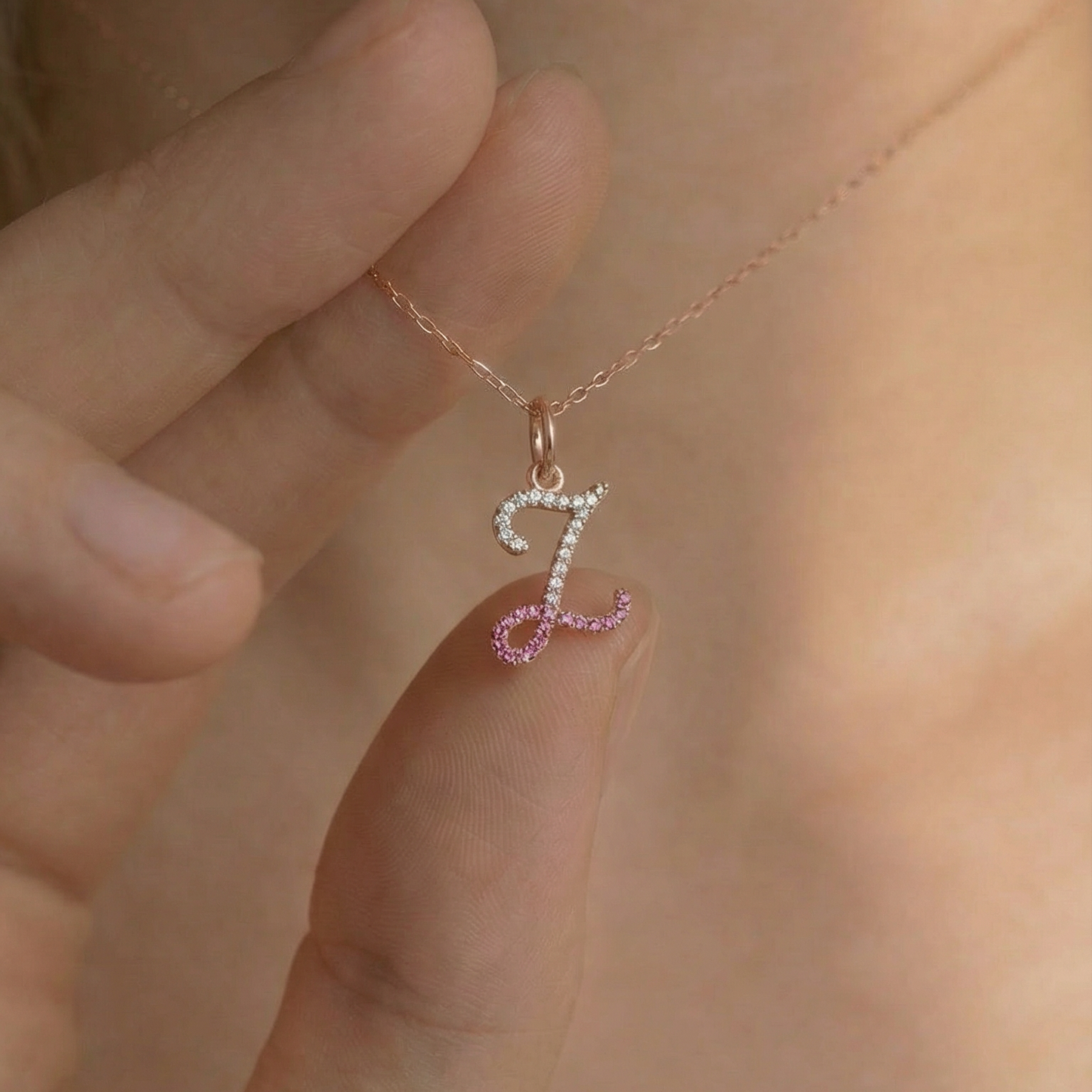 Necklace with a '7' pendant held by a hand against a blurred background
