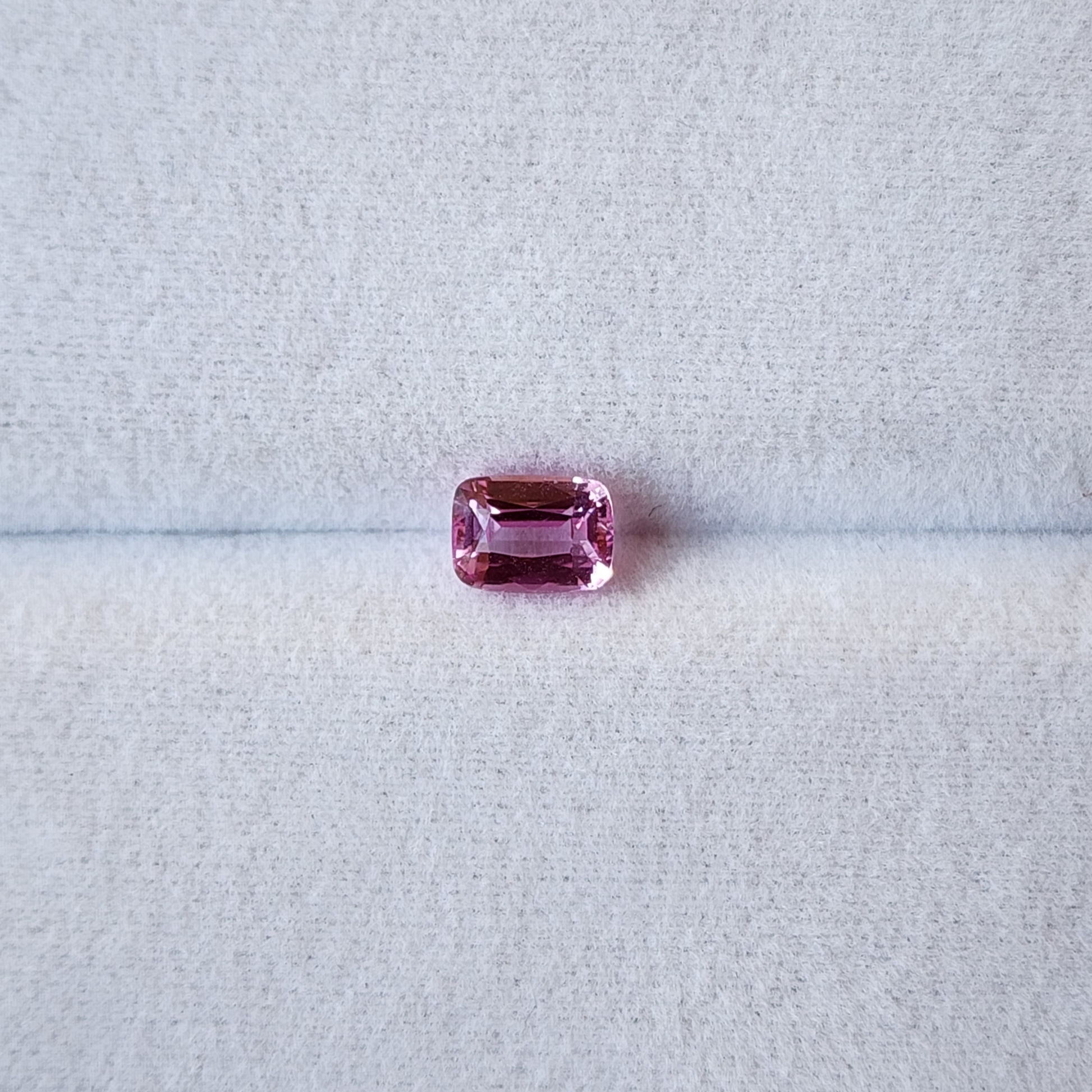 Pink gemstone on a light gray background