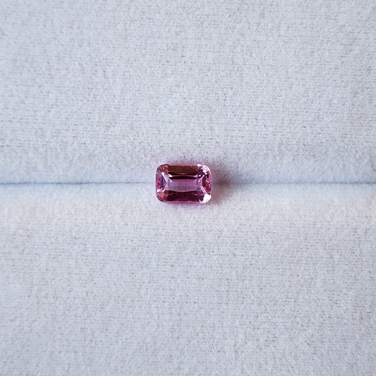 Pink gemstone on a light gray background