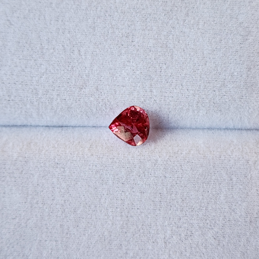Red gemstone on a light gray background