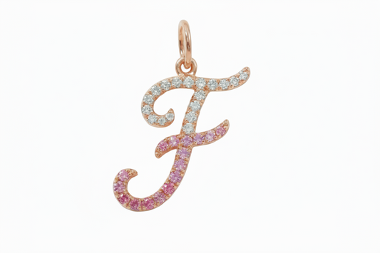 Rose gold letter 'F' pendant with pink and clear gemstones on a light gray background