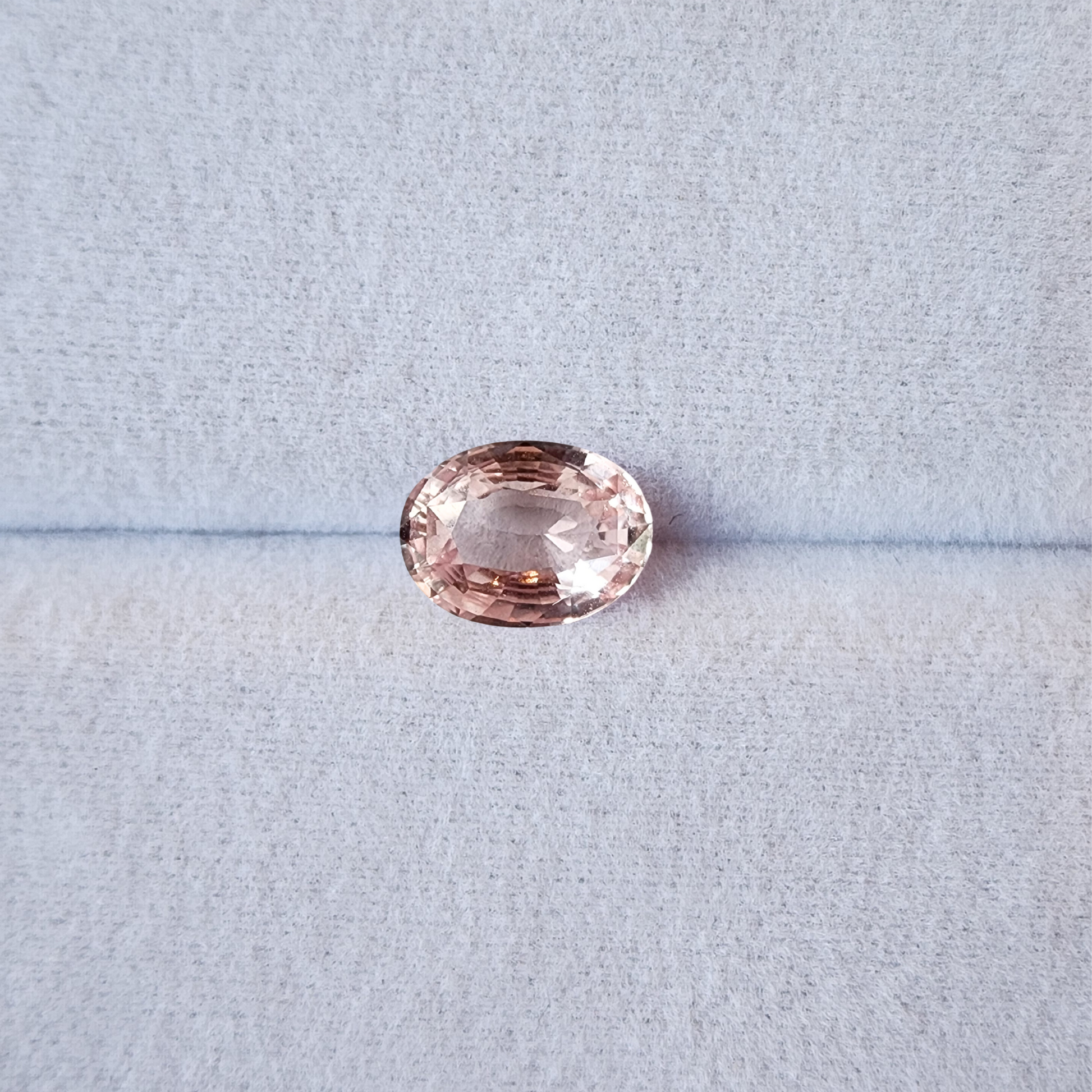 Pink gemstone on a light grey background