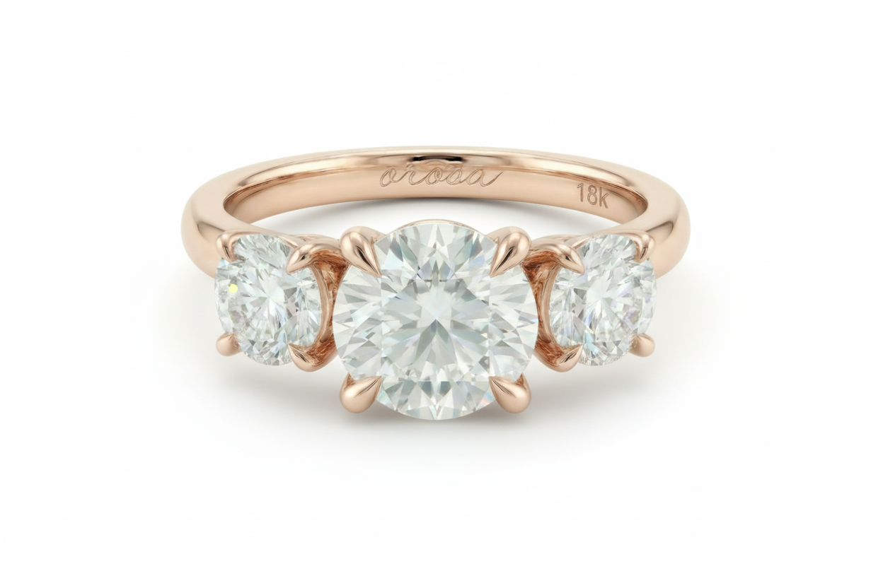 Rose gold ring with three diamonds on a light background