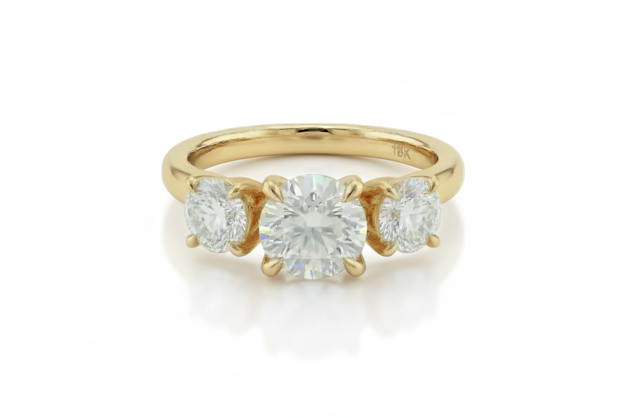 Gold ring with three diamonds on a light background