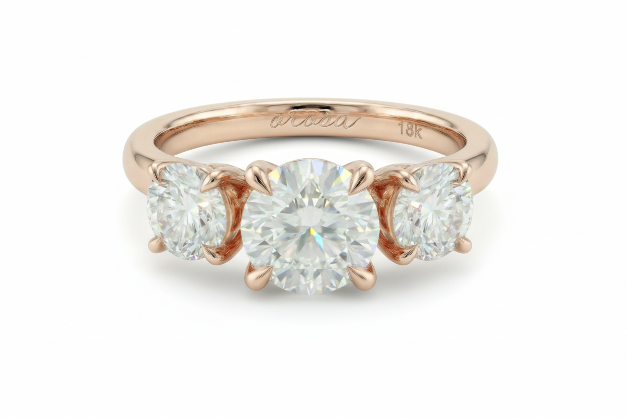 Rose gold three-stone diamond ring on a light background
