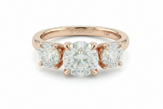 Rose gold three-stone diamond ring on a light background