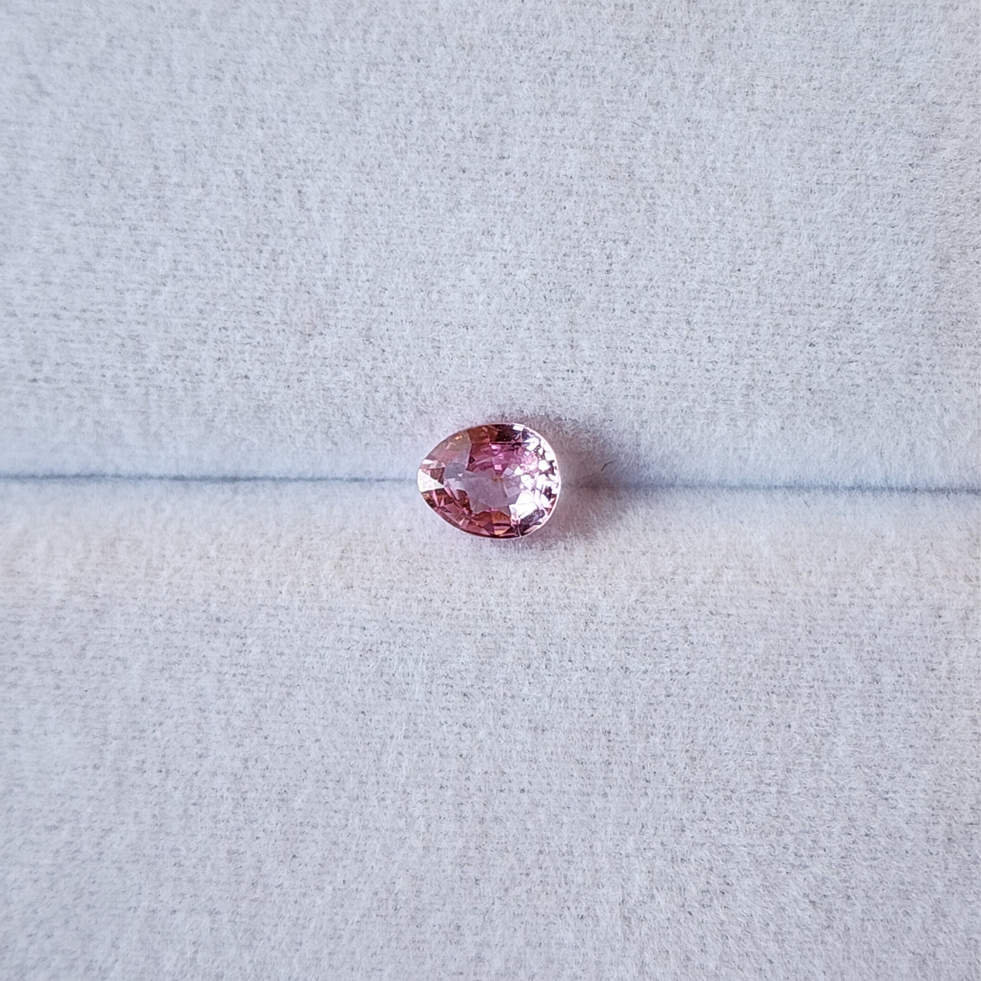 Pink gemstone on a light gray background
