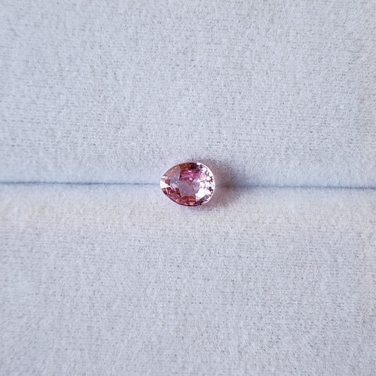 Pink gemstone on a light gray background