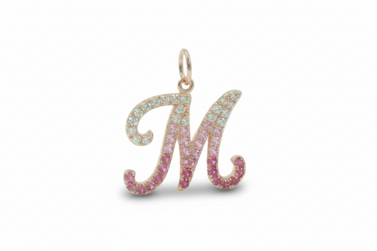 Letter 'M' pendant with pink and blue gemstones on a white background