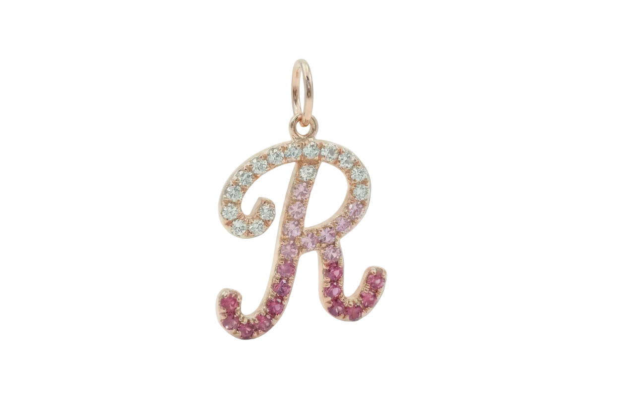 Rose gold pendant with 'R' and pink gemstones on a white background