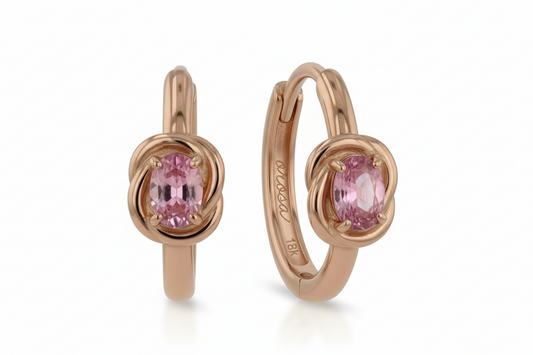 Rose gold hoop earrings with pink gemstones on a white background