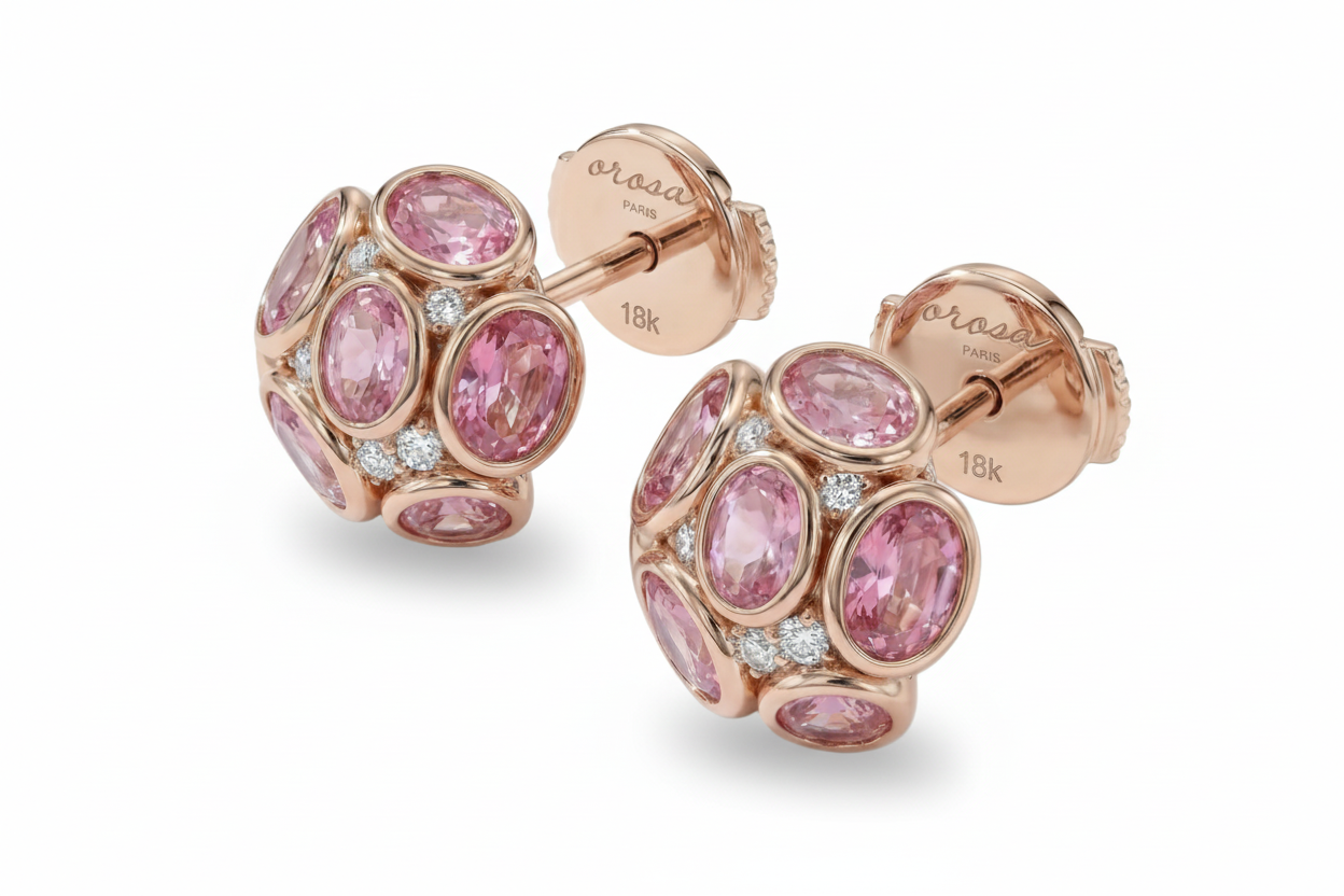 Rose gold earrings with pink gemstones on a white background