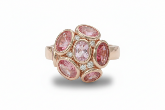 Ring with pink gemstones and rose gold setting on a light background