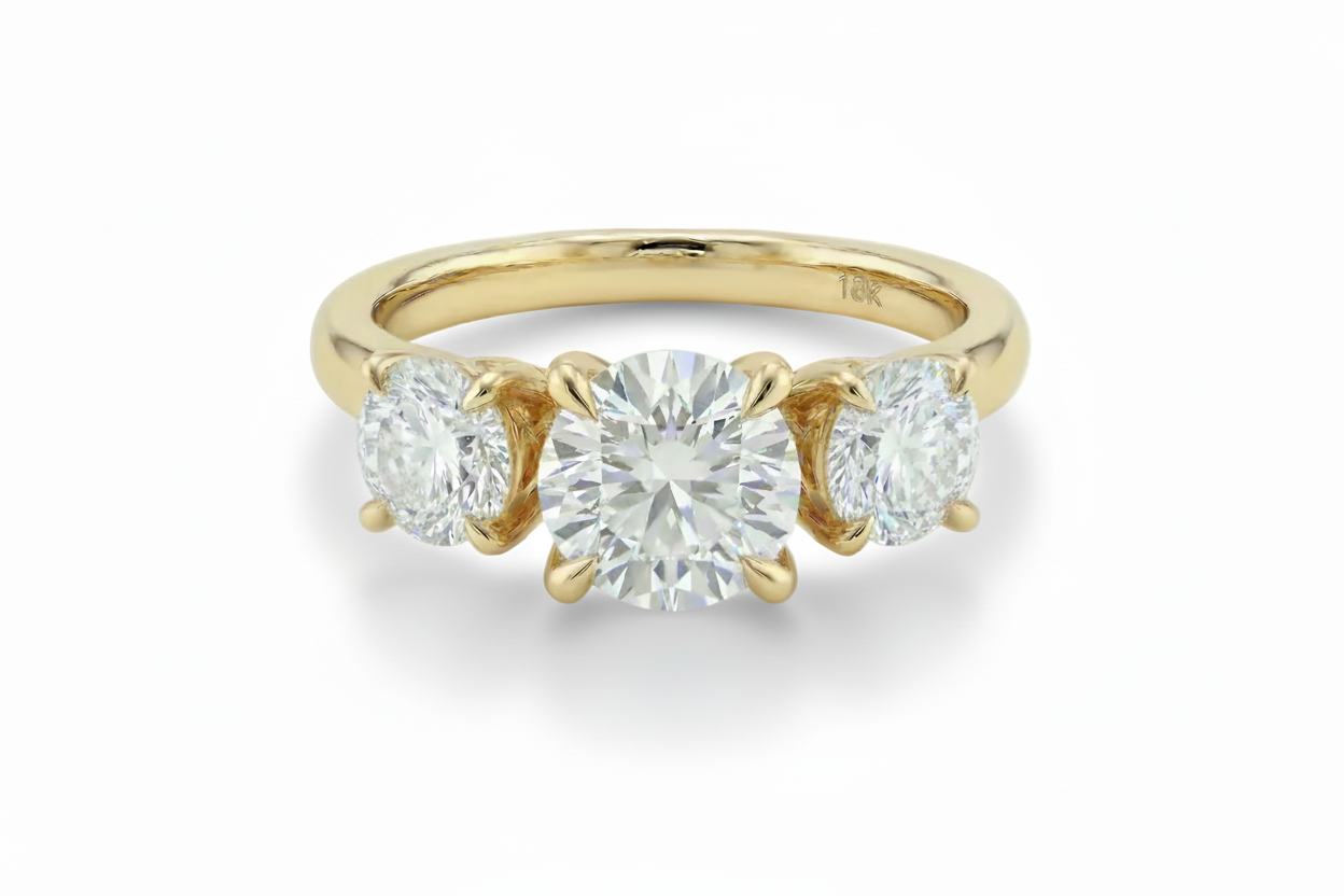 Gold ring with three diamonds on a light background